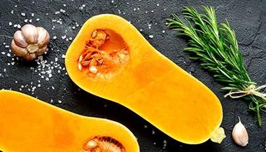Halved butternut squash with cloves of garlic